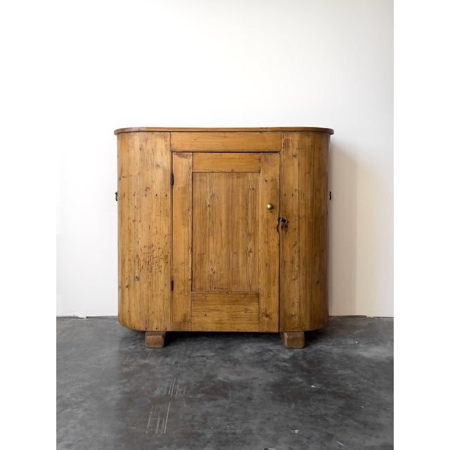 This rare 19th century English pine “huffer” cabinet features a distinctive curved silhouette and a warm patina....