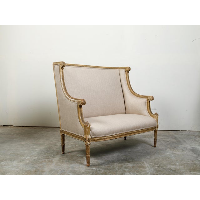 French 19th Century Louis XVI Style Giltwood Wingback Settee with Carved Motifs For Sale - Image 4 of 10