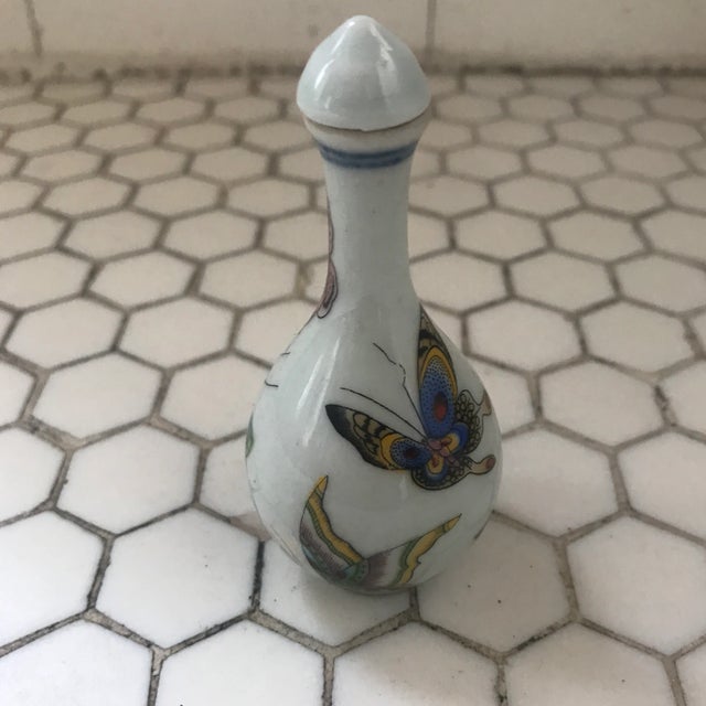 Chinese painted butterflies perfume/ snuff bottle adorned with a chinoiserie flowers in vase.