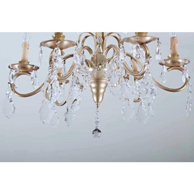 Beautiful chandelier made of patinated metal from the late 1940s. Hand-cut lead crystal trimmings. Functional. Restored...