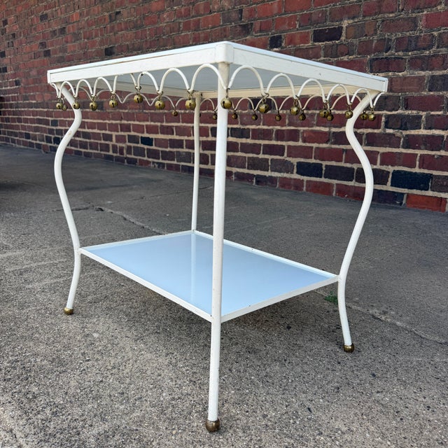 Rare and unusual Salterini outdoor metal side table with brass accents and white glass shelves. Both table tops can be...
