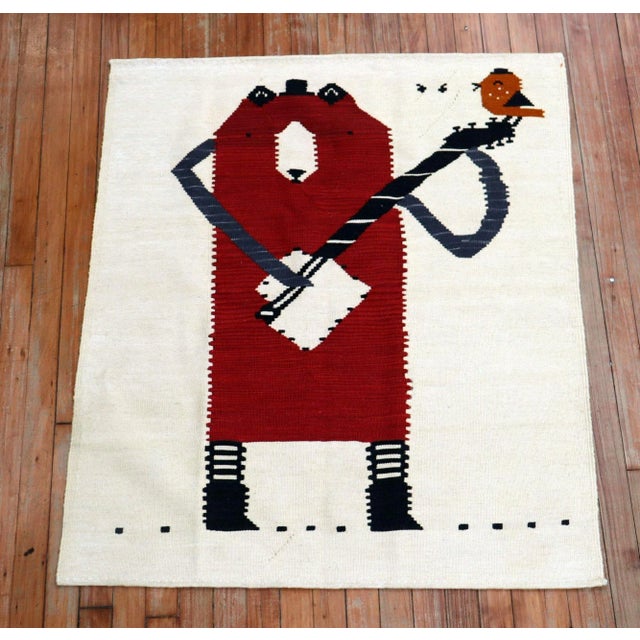 Scatter size Persian Kilim from the 20th century with a bear playing with his banjo. Looks like a small bird is tweeting...