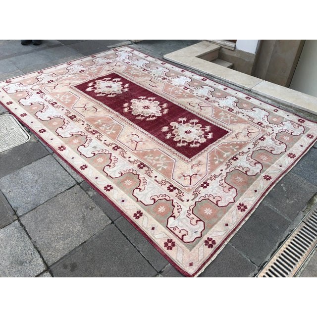 This is a vintage Turkish Oushak rug from the 1960s. The piece was hand-knotted.
