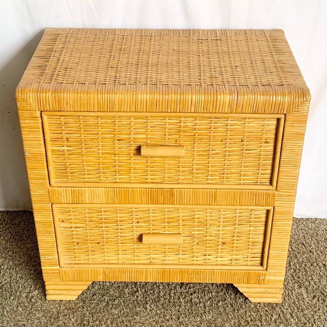 Vintage Boho Chic wicker nightstand featuring a warm honey finish and two spacious drawers with matching woven fronts....