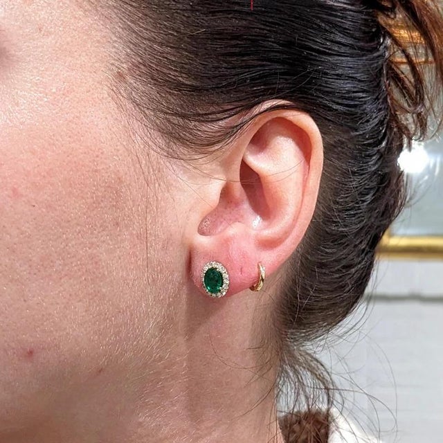 This sparkling earring set features a pair of vibrant earth mined emeralds with a pave diamond halo. A stunning pair of...