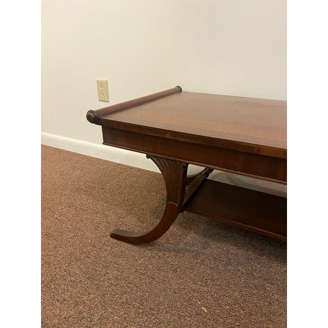 This is a beautiful inlaid top mahogany French Regency coffee table with lots of elegant flair and in good condition.