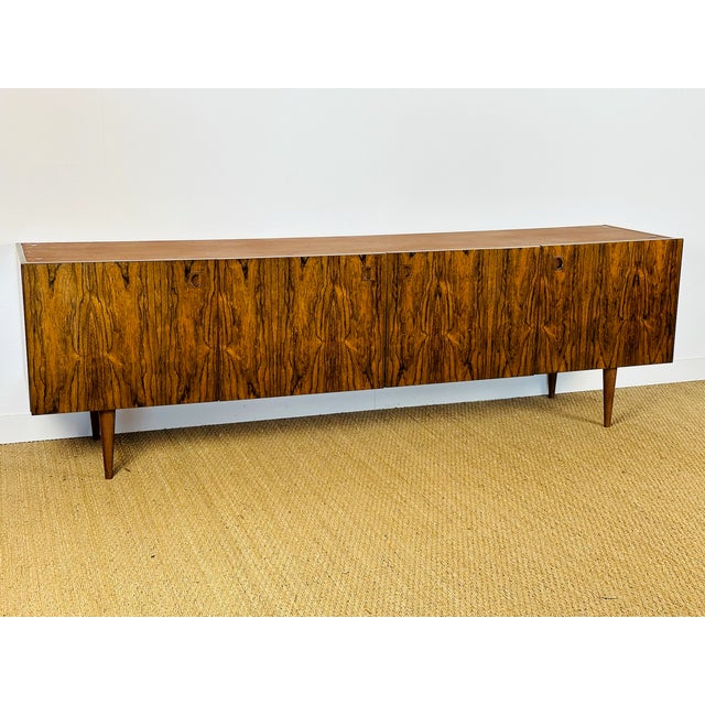 Stunning sideboard, a modernist design typical of 1960s Scandinavian furniture. The clean lines of the front feature four...