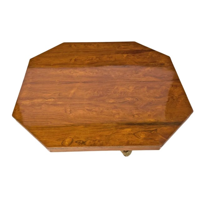 An octagonal rosewood dining table with gilt mounts and three leaves. The Regency style table is crafted of beautiful...