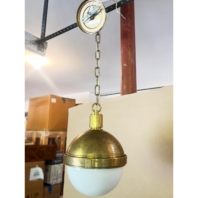 Lambert globe pendant light by Hudson Valley Lighting. A polished brass top fixture and a white glass shade make for a...