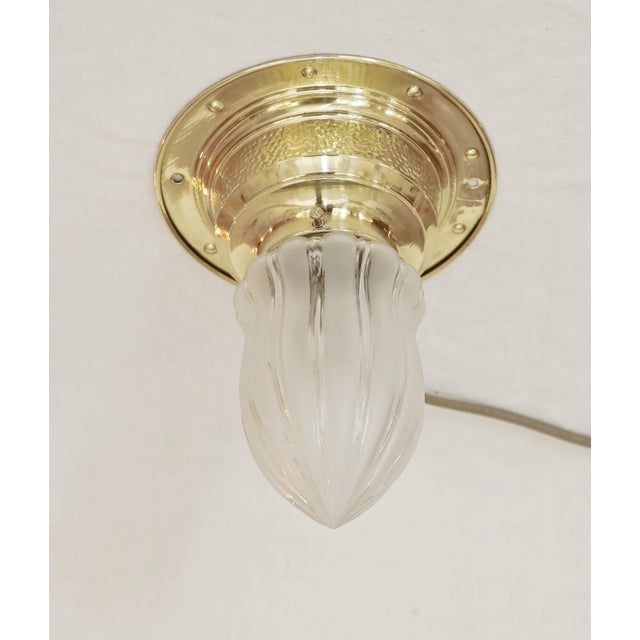 Art Nouveau brass ceiling lamp, circa 1910. Partially frosted clear glass shade. Hammered finish. The lamp has been...