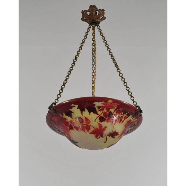 établissement Émile Gallé A French art deco hanging fixture in gild bronze with a Gallé bowl in acid-engraved cameo glass....