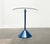 Postmodern side table with a heavy base and glass tabletop. The round glass tabletop is secured to the stem by two chrome-...