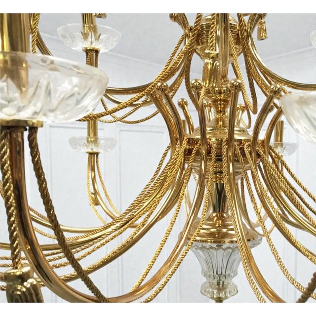 A stunning grand scale chandelier with an Old World Neoclassic elegance. The polished brass has arms featured in a rope...