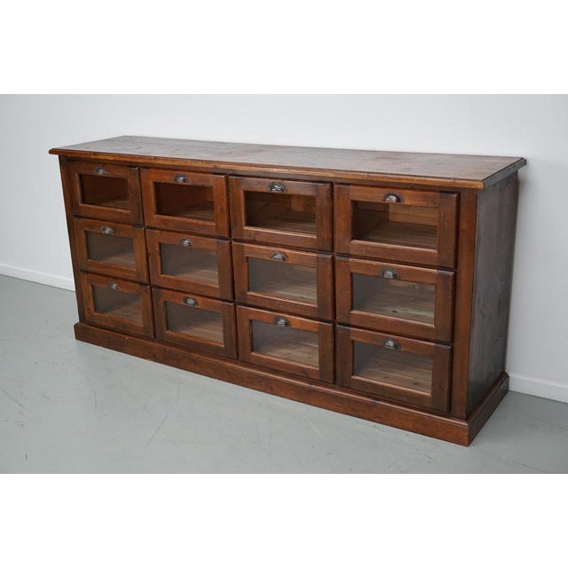 This vintage haberdashery cabinet was produced and designed in the Netherlands mid 20th century. This piece features 12...