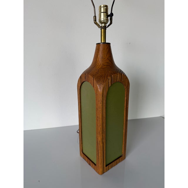 Vintage carved oak wood table lamp featuring an architectural bottle-form silhouette with inset green panels on each side....