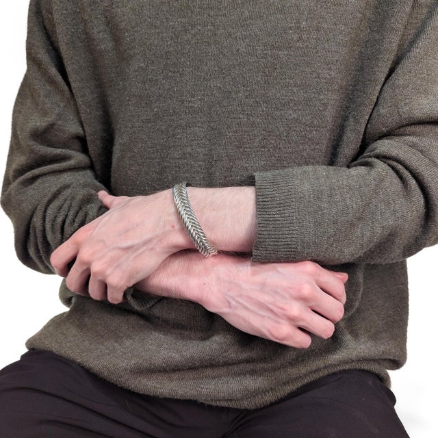 A fine signed silver Chevron cable cuff bracelet. By David Yurman. In sterling silver. In a chevron pattern. With a hinged...