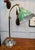 A charming antique reading lamp dating to circa 1920, combining a patinated brass gooseneck with its original green enamel...