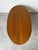 Elegant 1960s Hollywood Regency coffee table crafted in rich mahogany with a classic oval top featuring a subtle inlaid...