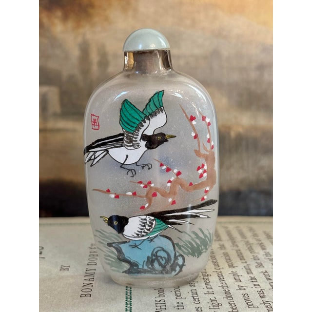 All Chinese snuff bottles are miniature works of art, yet this tall version stands out among them with its brightly-...