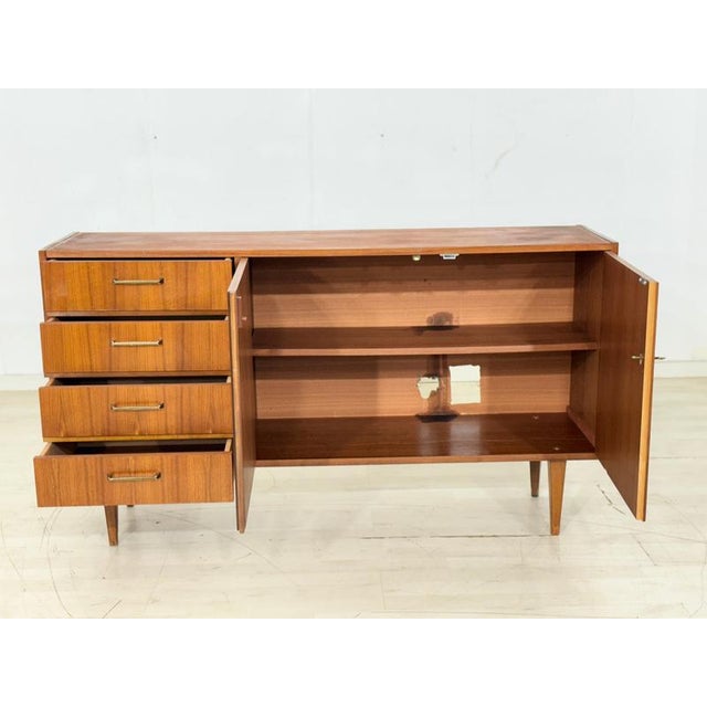 For sale is this beautiful, two-door teak sideboard with four drawers and slightly splayed legs, as shown in the attached...
