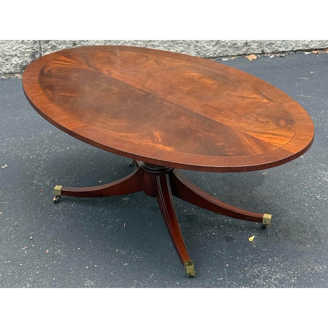 Beautiful regency style coffe table circa late 20th century. Features a striking flame Mahogany top with banded inlay...