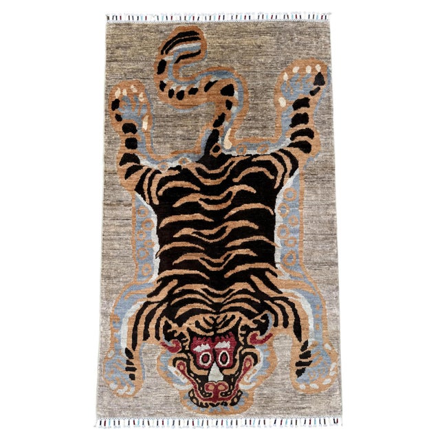 A hand-knotted rug in the Tibetan tiger design, woven on a natural grey ground with the full pelt laid out across the...