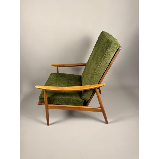 This vintage Scandinavian lounge chair features a solid beech frame and newly replaced green upholstery. with its...