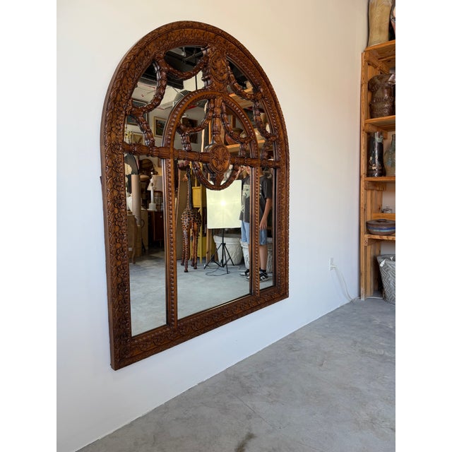 Exceptional large-scale wall mirror by John Richard, showcasing masterful craftsmanship in richly carved walnut. The...
