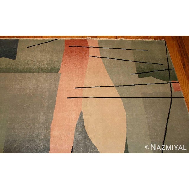 Crafted in China, this innovative art deco rug depicts a streamlined composition decorated with linear accents and...