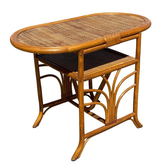 Simply yet elegant small Art Deco rattan side table with formed "Palm" decoration on both fronts with a rice mat top. The...