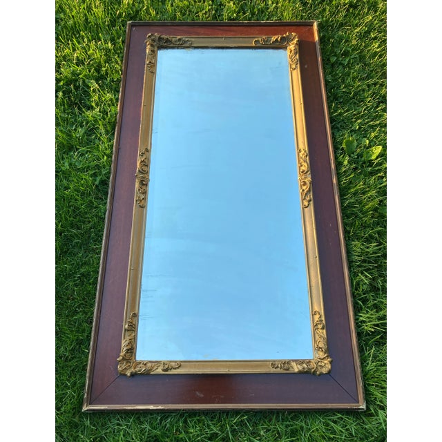 Impressive large beveled mirror with cherry border with carved gilt wood scrolling.