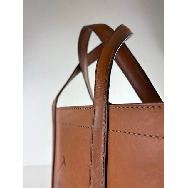 This is a handsome Ralph Lauren light brown tooled leather satchel. This light brown leather satchel has two substantial...