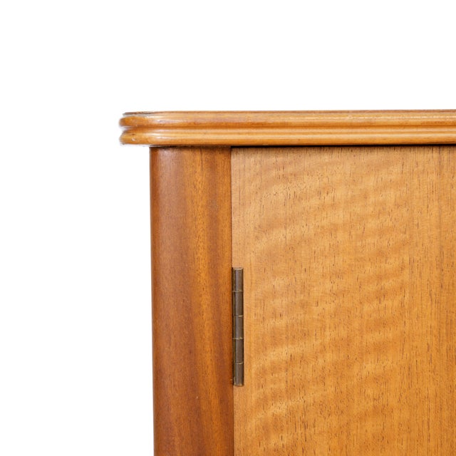 This vintage mid-century armoire was produced by A. Younger Ltd during the 1960s. Made from African Mahogany the two front...
