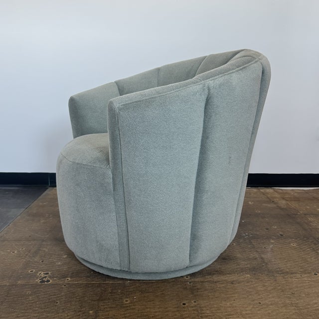 A sculptural take on the classic barrel chair, this swivel lounge chair pairs soft curves with a tailored channel-back...