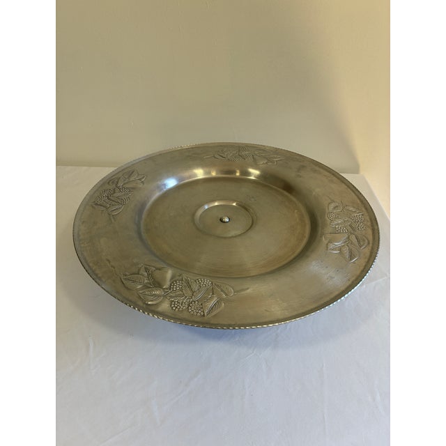 Striking vintage hand-wrought aluminum lazy Susan featuring a raised pedestal base, rotating tray, and an elegant embossed...