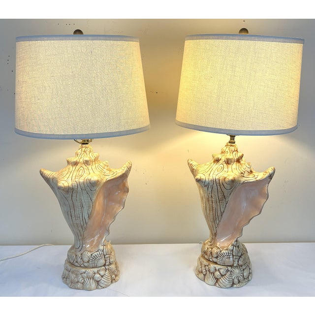 Fun vintage pair of coastal style table lamps from 1986. They are made of ceramic and shaped like large conch shells with...