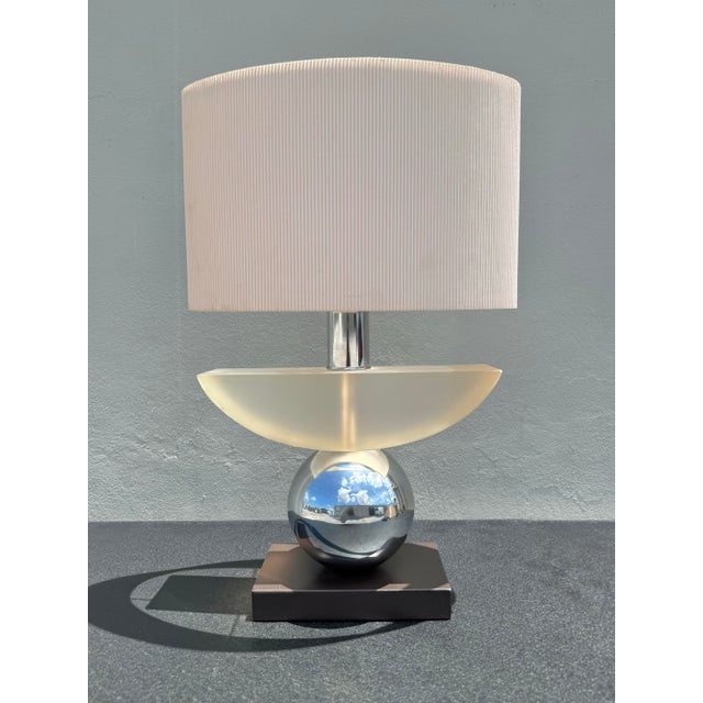 A striking vintage sculptural table lamp featuring a polished chrome sphere body, architectural chrome neck, and oversized...