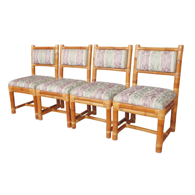 A set of four mid century modern elephant bamboo dining chairs. Thick bamboo pieces form the frame with rattan wrapping...