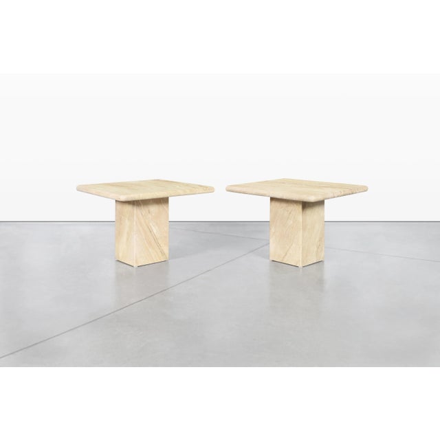 Crafted in Italy during the late 20th century, this exceptional pair of vintage travertine side tables embodies the...