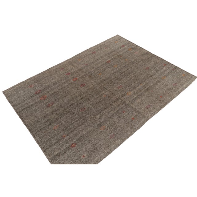 Originating between 1950-1960, a (9x10) vintage kilim rug from Turkey. Handwoven in wool, simple gray tones play with...