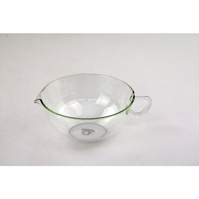 6 teacups with saucers, made of fireproof glass, plus a small handle jug for milk or lemon. This piece has an attribution...