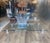 An elegant Louis XVI style coffee table by P.E. Guerin, featuring a rectangular glass top supported by four finely cast...