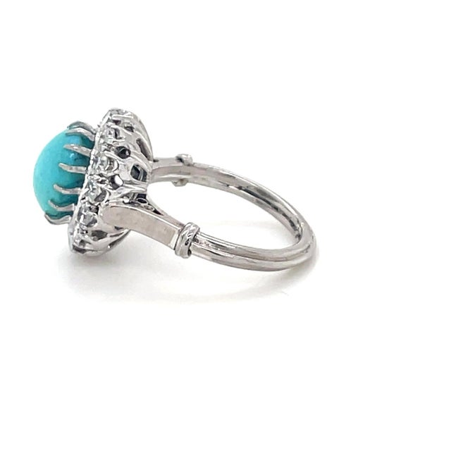 This gorgeous antique ring boasts an oval cabochon turquoise measuring approximately 8.80 x 7.10 x 4.96 mm, surrounded by...