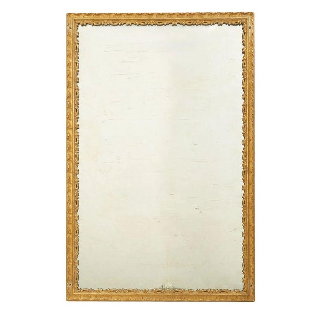 A vintage large giltwood mirror with intricately carved scroll details