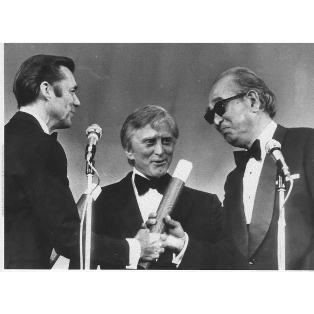 The Japanese director Akira Kurosawa receives the Gold Palm from the British Actor Dirk Bogarde and Kirk Douglas, for his...