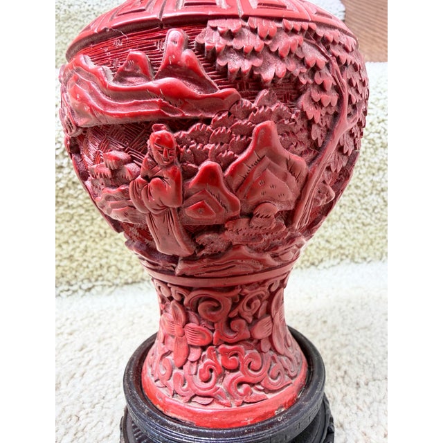 This is an antique Chinese Republic Era (1930’s) carved red cinnabar vase featuring intricate floral patterns on the neck...