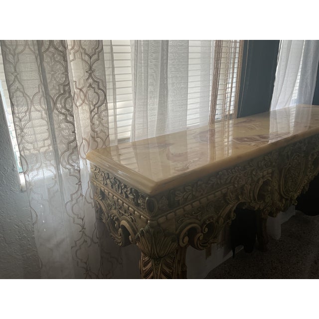 This gorgeous console table is a Baroque Revival / Rococo Revival in style. It was manufactured during the 1990s. This...