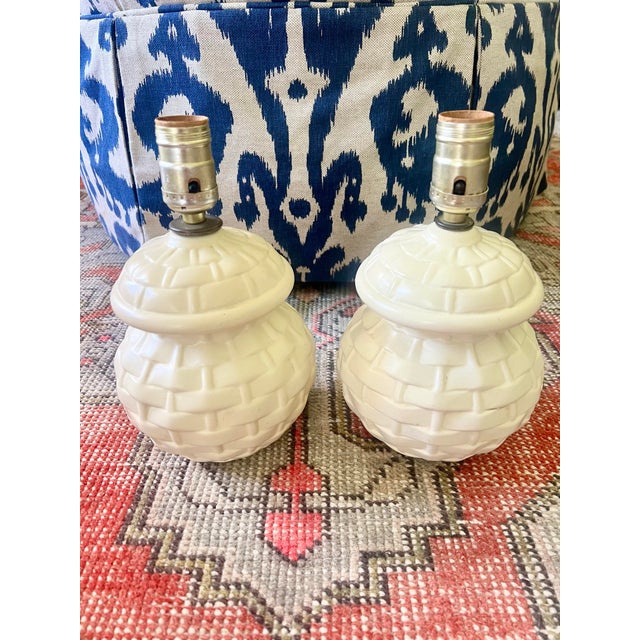 This precious pair of ceramic table lamps have a ginger jar shape and basket weave pattern. These are an off white or...