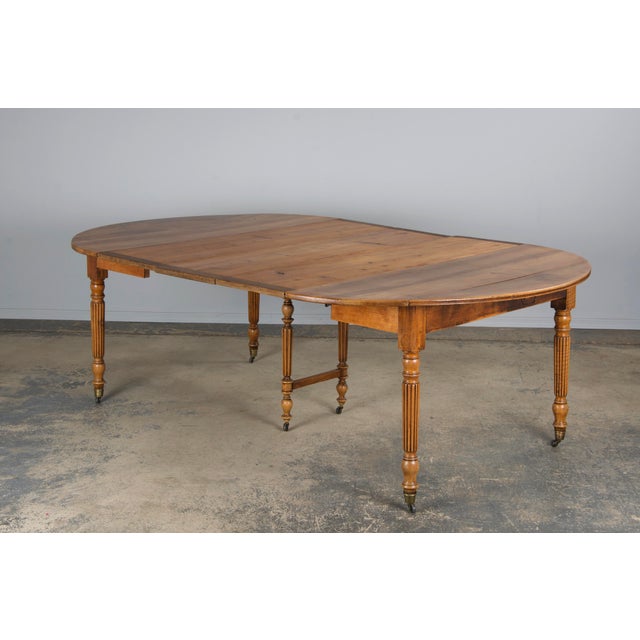 This late 19th century French Louis Philippe style drop-leaf oval extendable dining table hails from Provence and is...