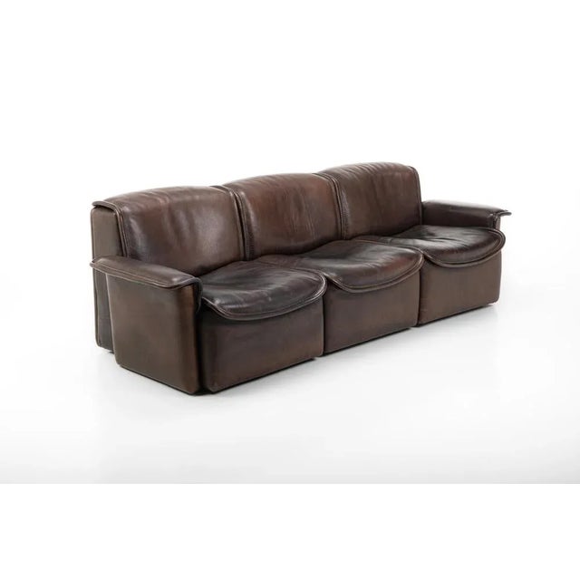 This exquisite vintage sofa, upholstered in dark brown buffalo leather, presents the DS12 model from the 1970s, crafted by...